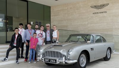 Barrie Wells with a group of people and an Aston Martin car.