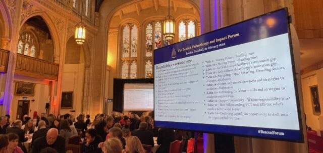 An image of participants at the Beacon Forum sitting talking at tables in the Guildhall in London